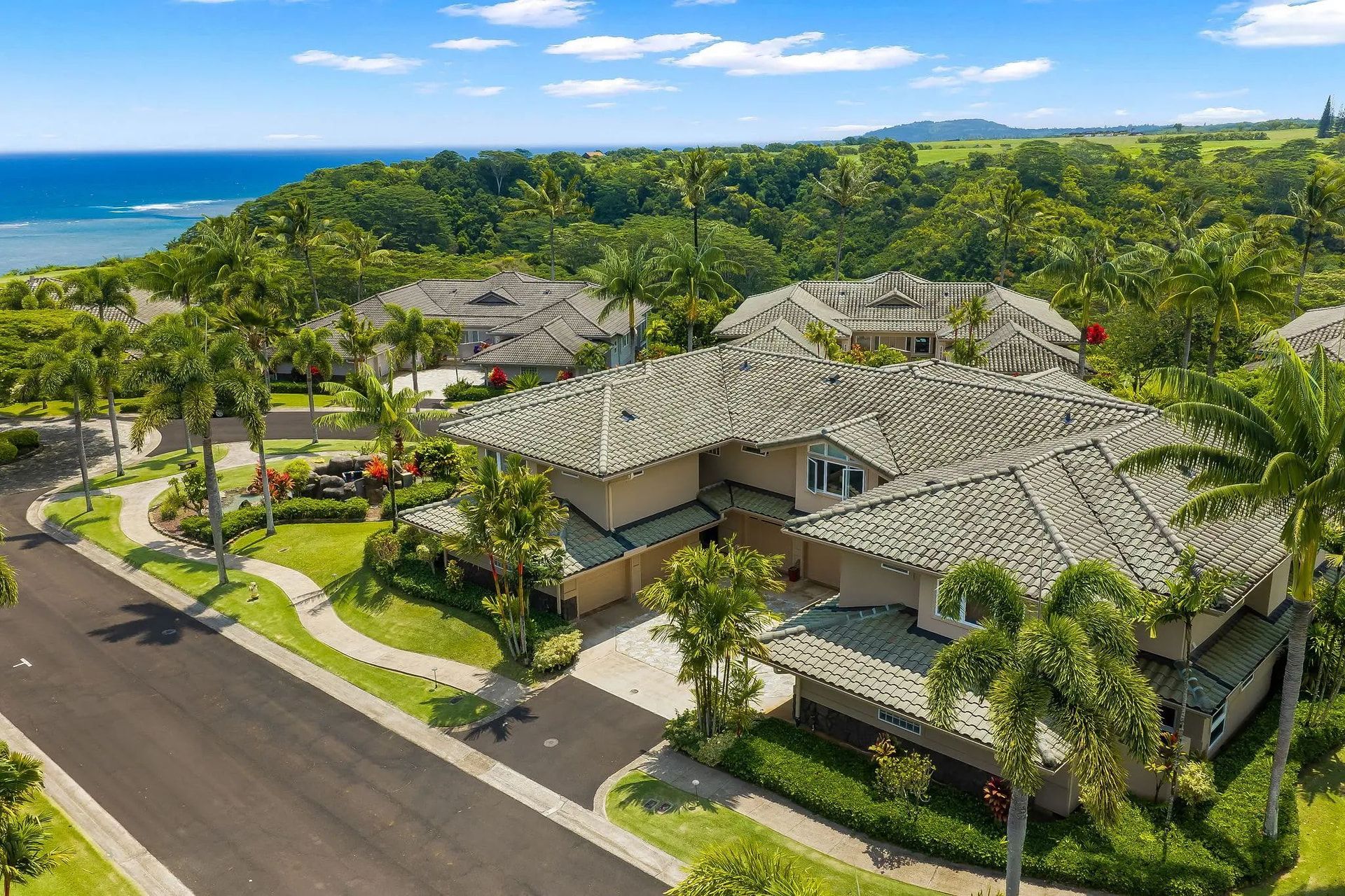 Un quartier résidentiel où les maisons sont dotées de toits en tuiles et sont entourées d’une végétation luxuriante.