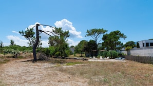 A dry, grassy area with scattered trees and a building in the background. - Apartment 'La Dolce Vita 8 - Le Cedrat' with Sea View, Wi-Fi and Air Conditioning (Borgo)