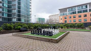 A chessboard set outdoors with buildings in the background.