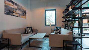 A modern living room with a sofa set, a coffee table, and a bookshelf.