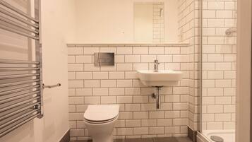 A bathroom with a toilet, sink, and shower.