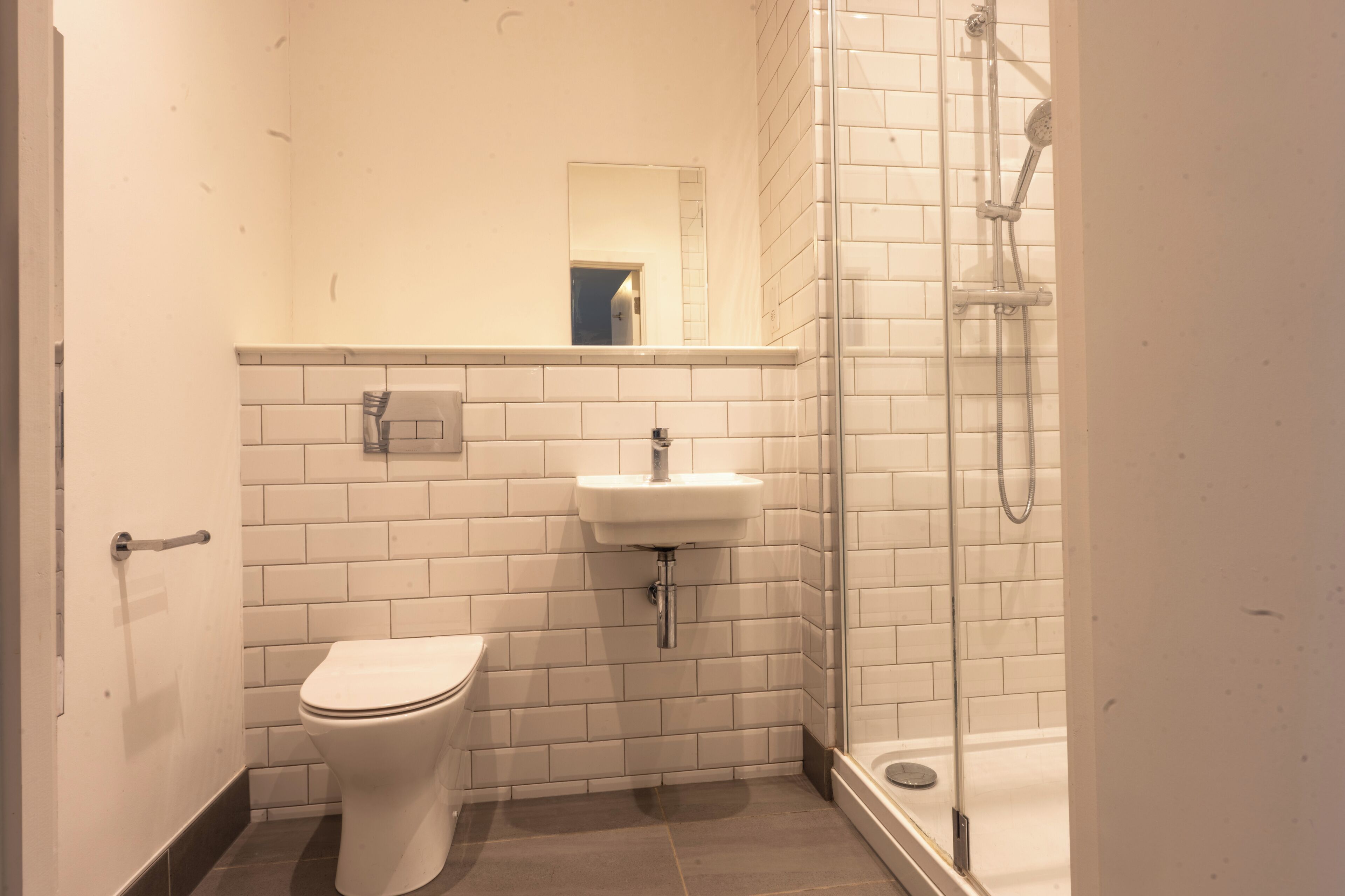 A bathroom with a toilet, sink, and shower.