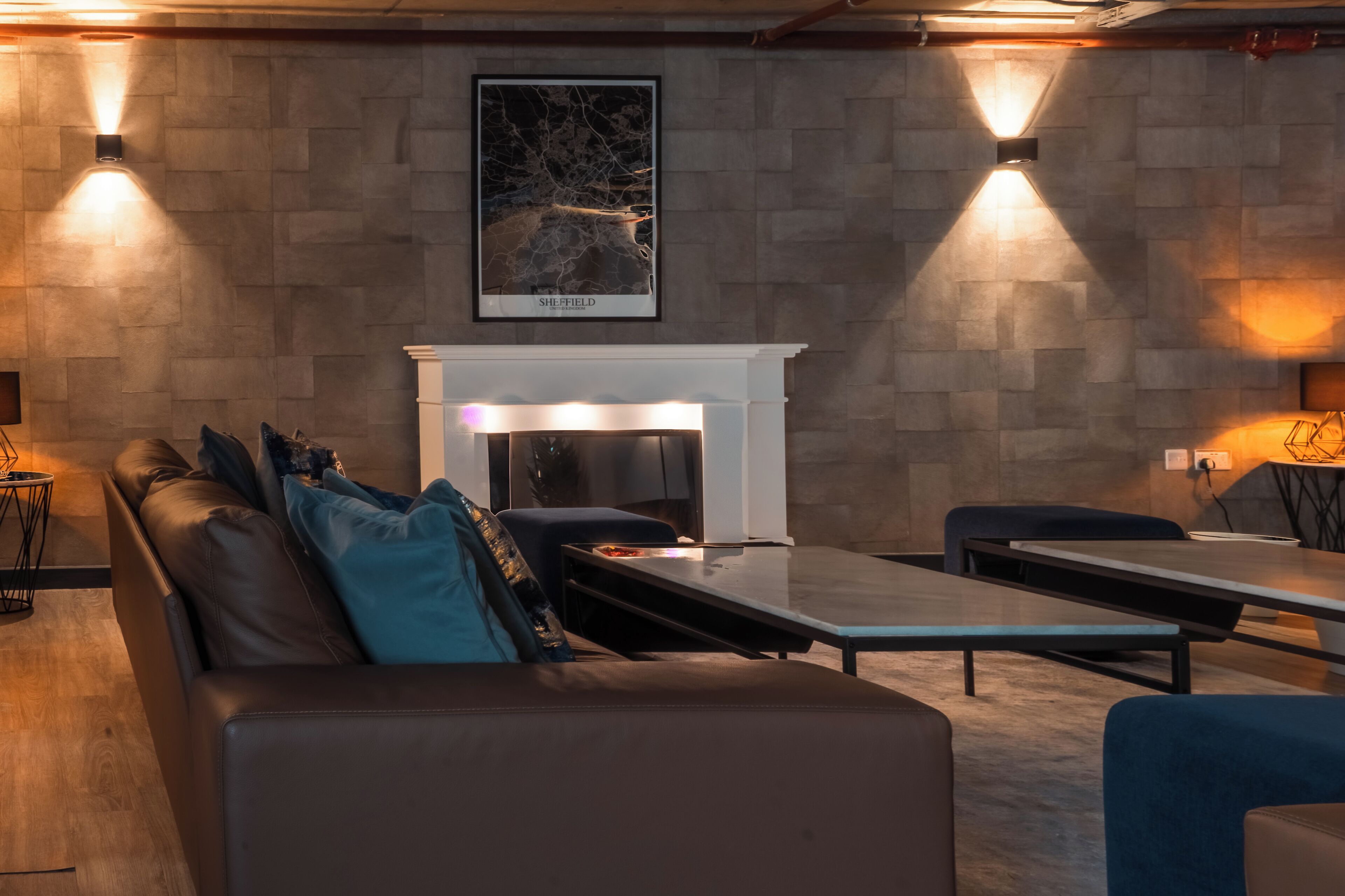 A modern lounge area with a fireplace, leather seating, and ambient lighting.