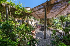 A covered outdoor area with a pergola, seating, and a potted plant. - Villa Ninfea - Capri Garden Retreat (Capri)