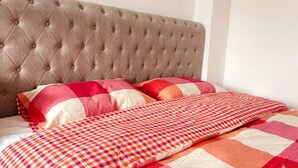 A bed with a tufted headboard, checkered bedding, and pillows. - Stylisg retreat with private entrance, minutes from blue water.Free parking (Stone)