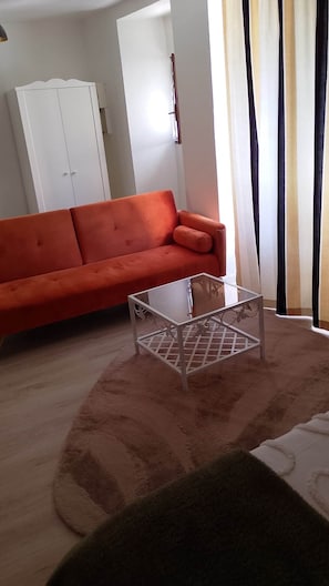 A living room with a sofa, a glass-top coffee table, and a white wardrobe. - Au Pied du Château, the Charm of Heritage (Vizille)