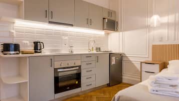 Una cocina moderna con armarios grises, un microondas y un horno empotrado.