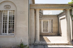 A building with classical architecture, featuring columns, a covered walkway, and barred windows. - Terranova Apartments by Andes STR (Providencia)
