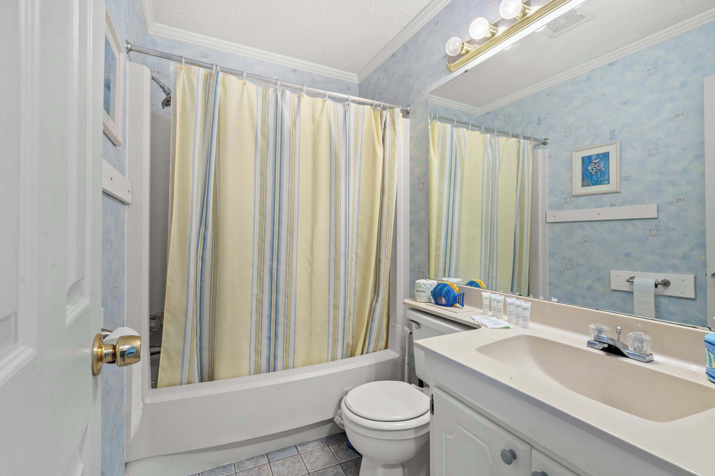 A bathroom with a bathtub, toilet, and sink.