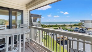 Un balcon avec vue sur la plage et le parking.