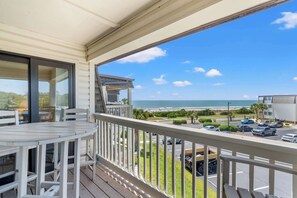 Ein Balkon mit Blick auf Strand und Parkplatz.