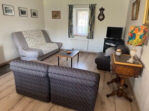 A living room with a sofa, a coffee table, a TV, and a lamp.