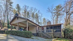 A two-story building with a covered porch and a staircase leading to the upper level.