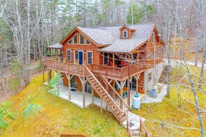 A log cabin with a deck, a staircase, and a large window. - Glen Laurel Cabin (Cullowhee)