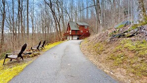 A rural road leading to a red cabin surrounded by trees. - Hawks Landing (Sylva)