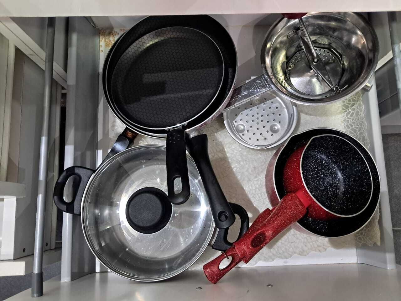 Une cuisine équipée d’une cuisinière, de casseroles et d’une bouilloire.