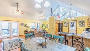 Eine geräumige Küche mit Essbereich, großen Fenstern und hoher Decke.