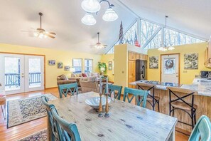 A spacious kitchen with a dining area, large windows, and a high ceiling. - Outstanding mountain home with firepit, fast WiFi, furnished deck, views & grill (Sylva)