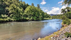 A river surrounded by dense forest and rocky terrain.
