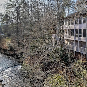 Un edificio con múltiples ventanas y balcones que dan a un río.