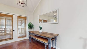 A room with a wooden bench, a white door with a window, and a large mirror on the wall. - Ripple Run (Sylva)