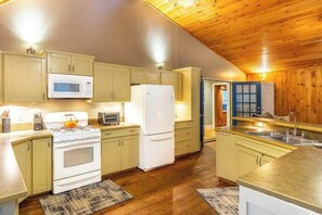 Une cuisine de taille réduite, dotée de meubles en bois, d’un four à micro-ondes, d’une cuisinière et d’un réfrigérateur.