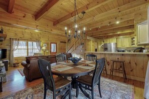 Ein Holzblockhaus-Interieur mit Essbereich, Küche und Wohnbereich.