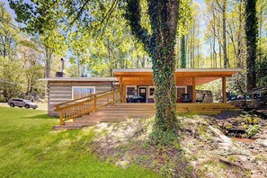 Eine Hütte mit einer Holzterrasse, einer Treppe und einer überdachten Veranda.