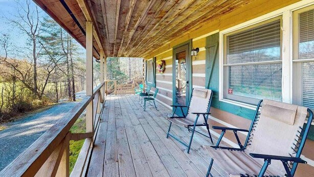 A wooden porch with a railing, a bench, and a window with blinds. - Family Jewel (Whittier)