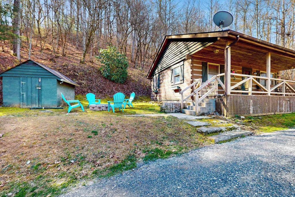 A cabin with a porch, a small shed, and outdoor seating.