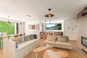 A modern living room with a sofa, a dining table, and a kitchen area with a large window. - Villa in Carqueiranne, 5 bedrooms, 5 bathrooms, heated pool, air conditioning. Beach 2.5km away (Carqueiranne)