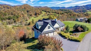 A house with a sloped roof, surrounded by a well-maintained lawn and trees. - Everview (Waynesville)