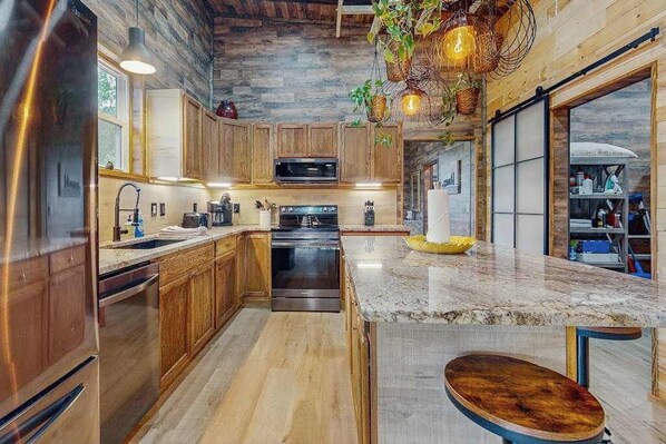 Una cocina moderna con armarios de madera, encimera de granito y horno empotrado.