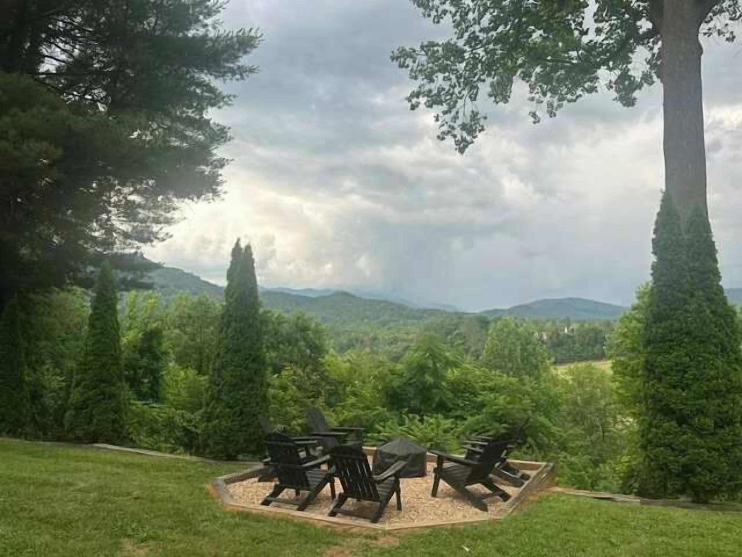 A patio with outdoor furniture, surrounded by trees and a view of distant mountains.