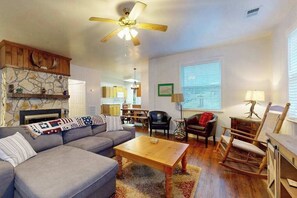 Ein Wohnzimmer mit Sofa, Couchtisch, Schaukelstuhl und Kamin.