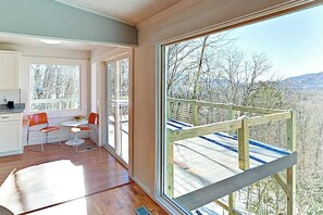 Ein modernes Interieur mit großen Fenstern, einem Holzboden und Blick auf eine verschneite Landschaft.
