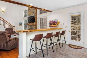Ein modernes Interieur mit Barbereich, Sitzgelegenheiten und einer Treppe.