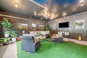 Ein stilvoller Lounge-Bereich mit einer Couch, Sesseln, einem Couchtisch und Blumentöpfen.