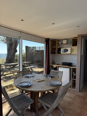 A dining area with a round table, chairs, and a view of the outdoors.