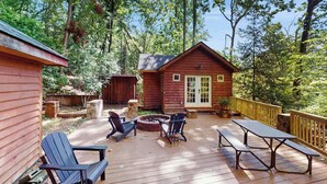 A wooden cabin with a deck, outdoor seating, and a fire pit. - Scenic cabins with fireplaces, children's items, W/D - dog-friendly (Horse Shoe)
