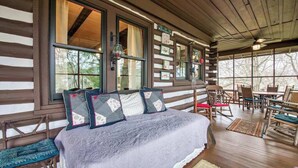 Ein Schlafzimmer einer Blockhütte mit Bett, Stühlen und Tisch.