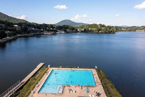 Ein Pool mit Blick auf einen See und Berge im Hintergrund.