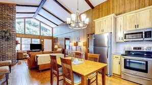Un'ampia cucina con mobili in legno, un tavolo da pranzo e una grande finestra.