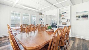 A dining room with a wooden table and chairs, a bookshelf, and a painting on the wall. - Junaluska Lodge (Lake Junaluska)