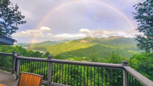 A deck with a view of a mountain range and a rainbow. - Mountain gem w/pool,golf, hot tub, tennis, beach, wellness center - dog-friendly (Lake Lure)