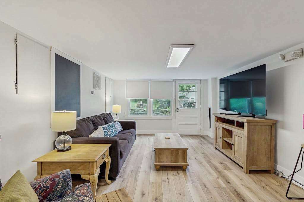 Un salon avec un canapé, une table basse, un téléviseur et un meuble en bois.