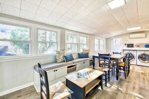 A kitchen with a built-in bench, a table with a chessboard, and a washing machine. - Spacious dog-friendly Montreat cottage with firepit, mountain views, & patio (Montreat)