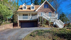 Une maison à deux étages avec un porche à l’avant, un garage et un escalier menant au deuxième étage.