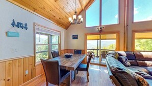 A wooden interior with a dining table, chairs, and a sofa. - Sun Eagle Lodge (Bryson City)