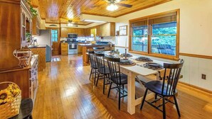 Un interior de madera con comedor, cocina y ventanas amplias.